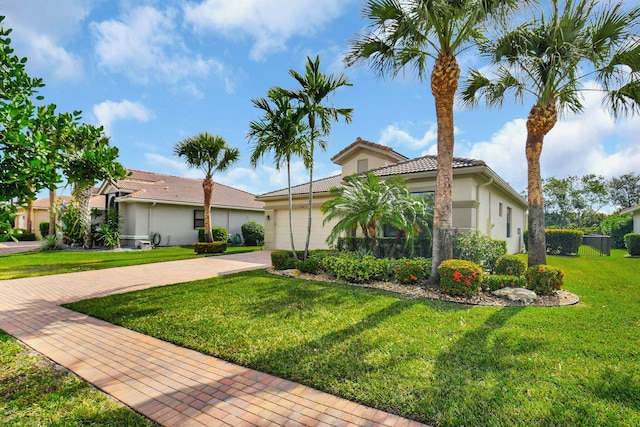 9380 Isles Cay Dr, Delray Beach, FL 33446 - view of front of house with stucco siding, a front lawn, decorative driveway, a tiled roof, and a garage