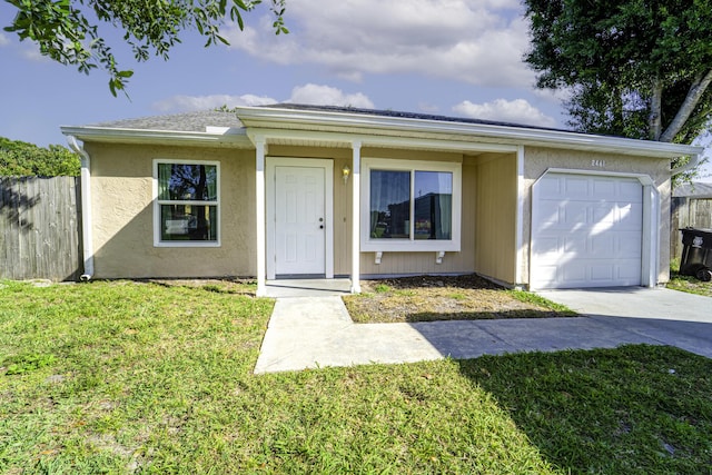 ranch-style home featuring an attached garage, fence, driveway, and a front lawn
