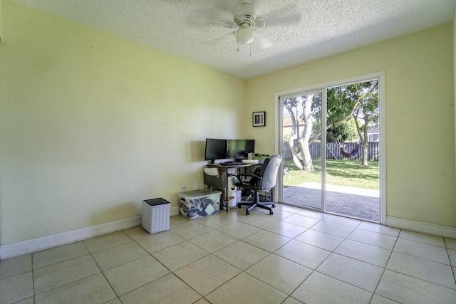 tiled office space featuring a textured ceiling, ceiling fan, and baseboards