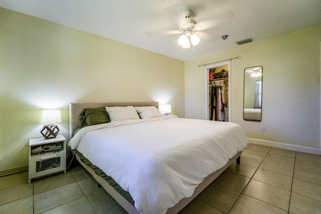 bedroom with baseboards, visible vents, light tile patterned floors, and a closet