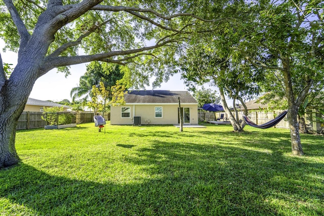 view of yard featuring a fenced backyard and central AC