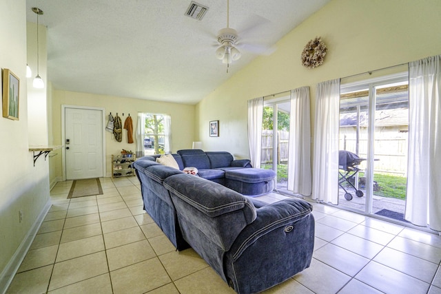 living room with plenty of natural light, ceiling fan, lofted ceiling, and light tile patterned flooring