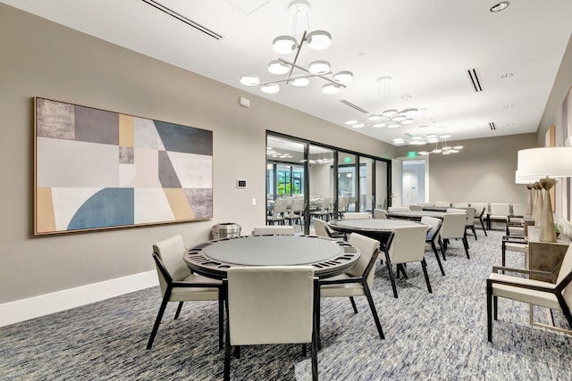 dining room featuring carpet floors, visible vents, baseboards, and an inviting chandelier