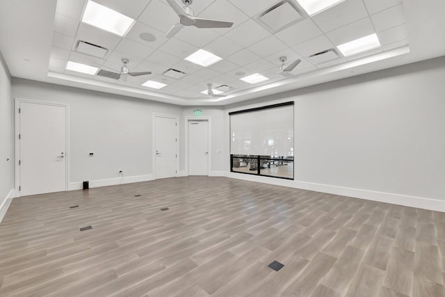 unfurnished room featuring a ceiling fan, light wood finished floors, baseboards, visible vents, and a paneled ceiling