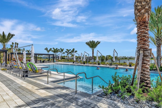 pool with a patio area and fence