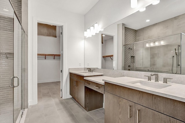 10130 Driftwood Way, Palm Beach Gardens, FL 33412 - bathroom featuring a walk in closet, double vanity, a shower stall, and tile patterned floors
