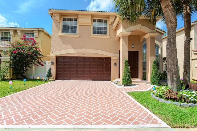 mediterranean / spanish-style house featuring stucco siding, decorative driveway, and an attached garage