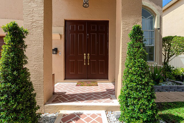 doorway to property featuring stucco siding