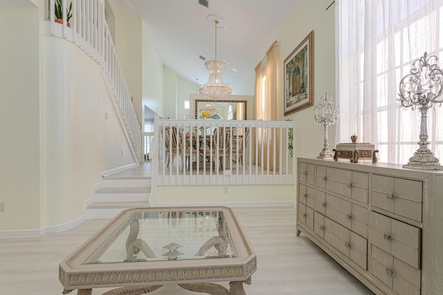 staircase with a chandelier, wood finished floors, and baseboards