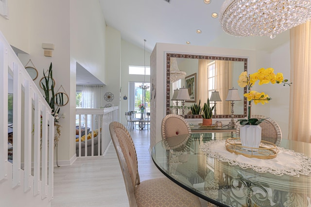 dining space with a chandelier, wood finished floors, stairs, recessed lighting, and high vaulted ceiling