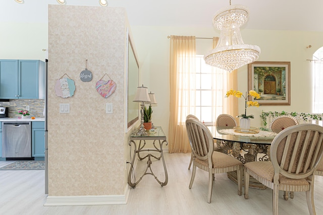dining room with a chandelier, light wood-style floors, and baseboards