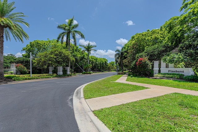 view of asphalt street featuring curbs and sidewalks