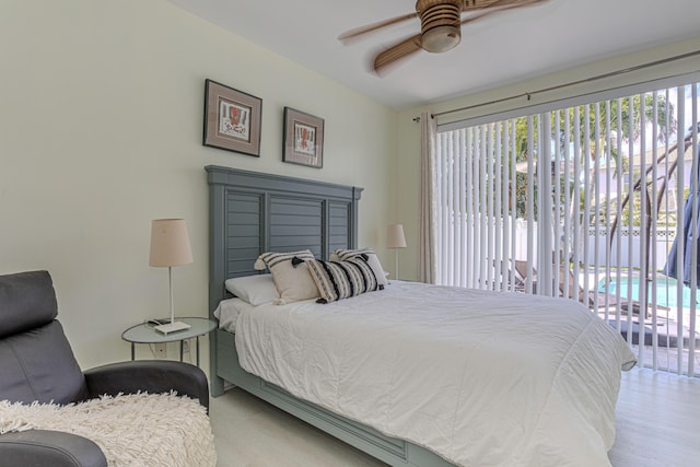 bedroom with multiple windows, access to outside, wood finished floors, and ceiling fan