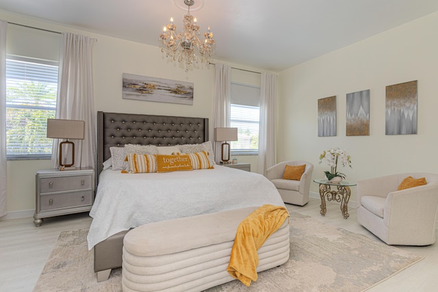 bedroom with a chandelier, wood finished floors, and baseboards