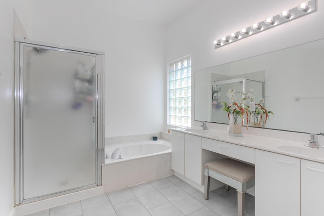 bathroom with a garden tub, a stall shower, double vanity, and tile patterned flooring