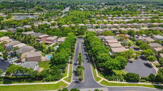 aerial view of property and surrounding area featuring a large body of water and nearby suburban area