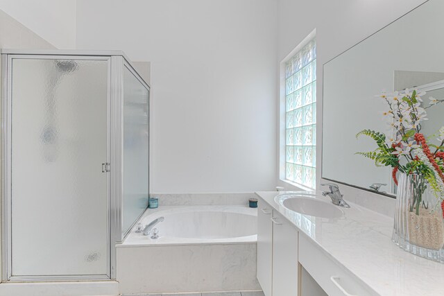 full bathroom with a shower stall, vanity, and a bath