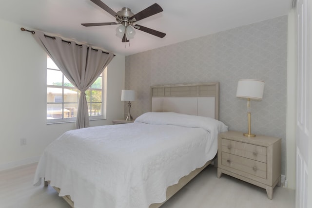 bedroom featuring baseboards, a ceiling fan, wallpapered walls, and light wood-style floors