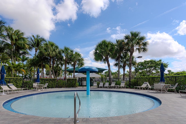 community pool with fence and a patio
