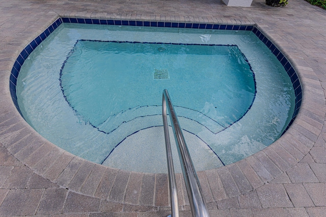 view of swimming pool with a hot tub and a swimming pool