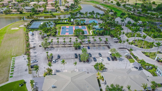 aerial view of residential area featuring a nearby body of water and a golf course