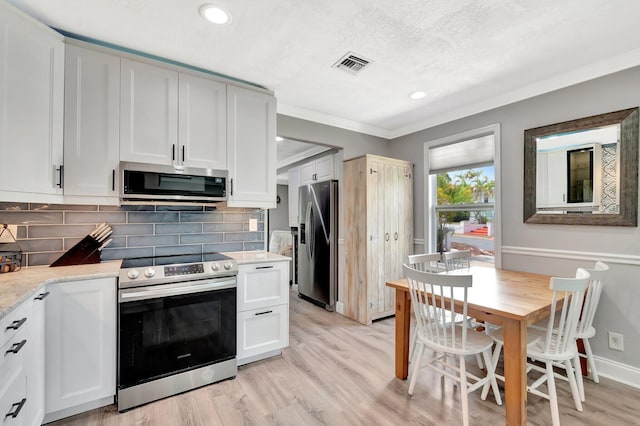 850 Green St, West Palm Beach, FL 33405 - kitchen with appliances with stainless steel finishes, tasteful backsplash, white cabinetry, and visible vents