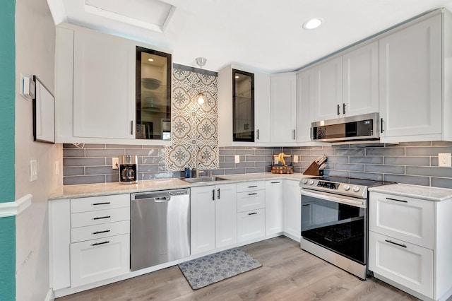 850 Green St, West Palm Beach, FL 33405 - kitchen featuring stainless steel appliances, white cabinetry, and tasteful backsplash