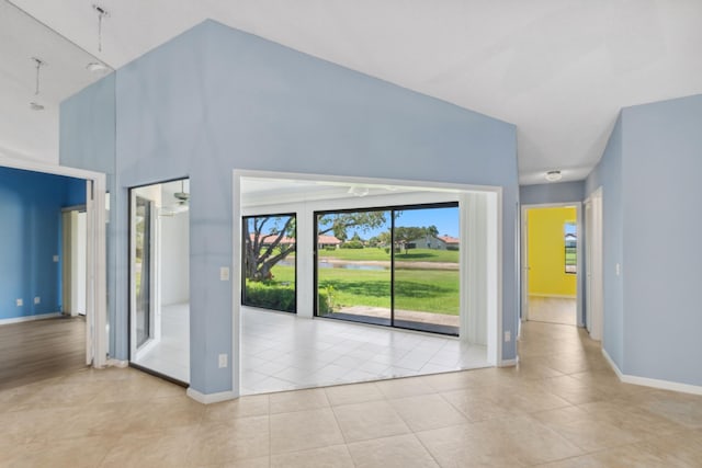 5942 Parkwalk Cir W, Boynton Beach, FL 33472 - interior space featuring a water view, a towering ceiling, baseboards, and light tile patterned floors