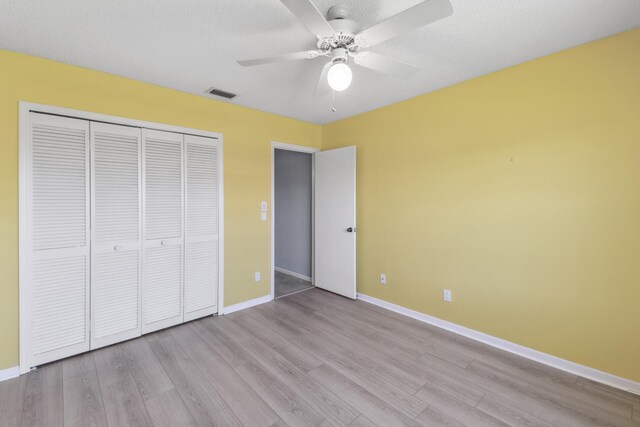 5942 Parkwalk Cir W, Boynton Beach, FL 33472 - unfurnished bedroom featuring wood finished floors, a closet, baseboards, a textured ceiling, and a ceiling fan