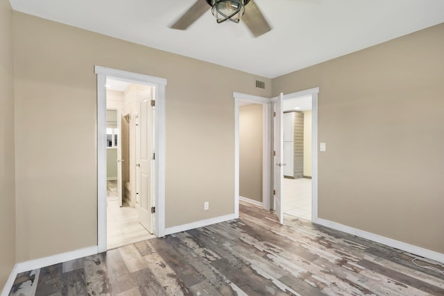 1116 Lake Ter Unit 203, Boynton Beach, FL 33426 - unfurnished bedroom featuring wood finished floors, baseboards, connected bathroom, and ceiling fan