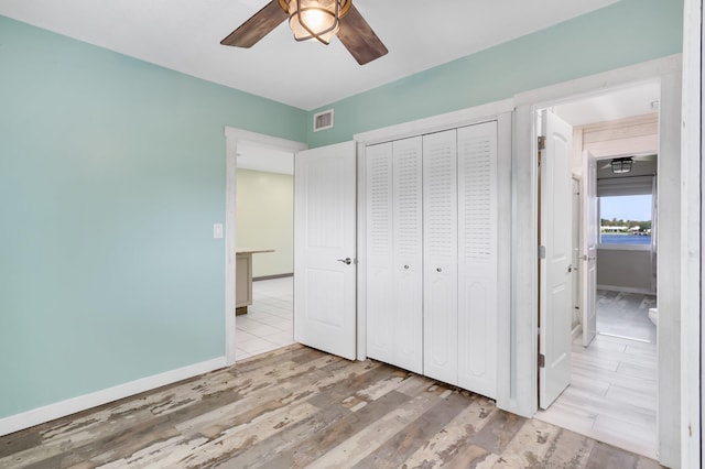 1116 Lake Ter Unit 203, Boynton Beach, FL 33426 - unfurnished bedroom with wood finished floors, a closet, baseboards, and a ceiling fan