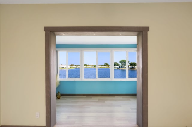 1116 Lake Ter Unit 203, Boynton Beach, FL 33426 - hall featuring wood finished floors, plenty of natural light, baseboards, and a water view