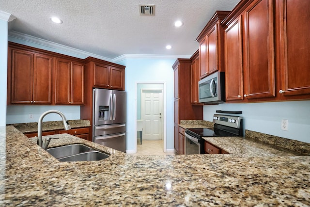 kitchen featuring appliances with stainless steel finishes, a sink, ornamental molding, light stone counters, and reddish brown cabinets