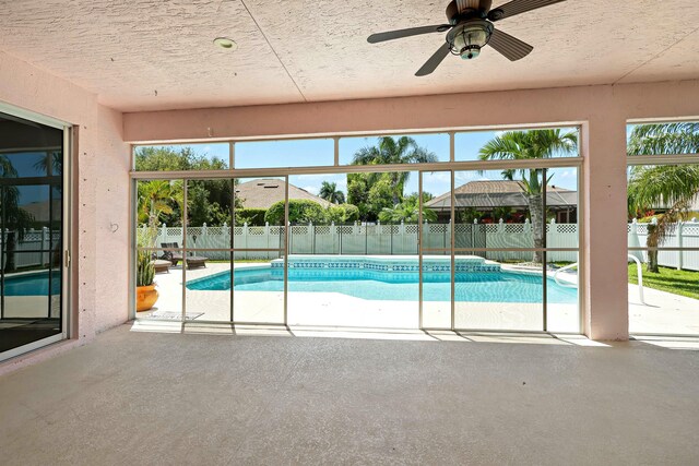 view of swimming pool featuring a patio area, a fenced backyard, and a ceiling fan
