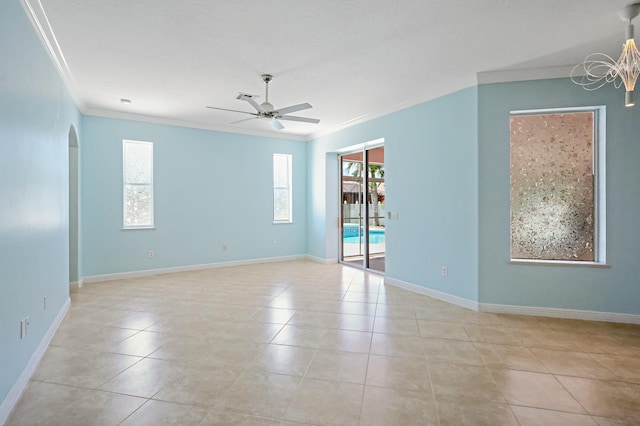 empty room with crown molding, arched walkways, a ceiling fan, light tile patterned floors, and baseboards