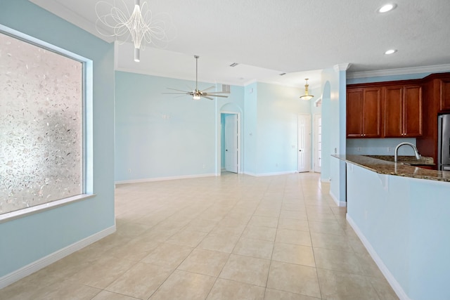 kitchen featuring dark stone counters, freestanding refrigerator, recessed lighting, light tile patterned floors, and baseboards