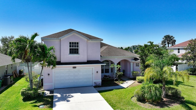 view of front of property with stucco siding, an attached garage, driveway, and central AC