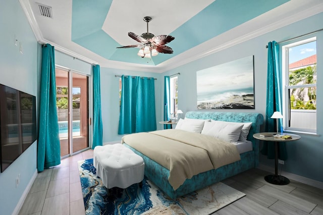 bedroom with access to exterior, baseboards, ceiling fan, a tray ceiling, and crown molding