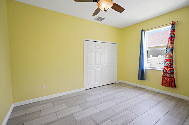 unfurnished bedroom with a closet, baseboards, and a ceiling fan