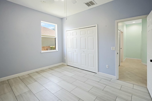 unfurnished bedroom featuring a closet, a ceiling fan, baseboards, and light tile patterned flooring