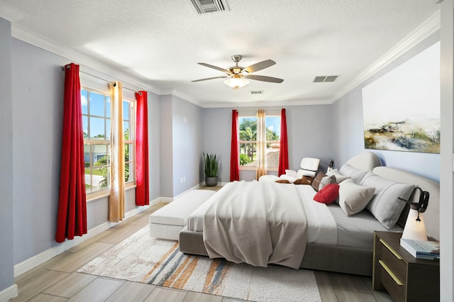 bedroom featuring ornamental molding, a textured ceiling, baseboards, a ceiling fan, and light wood-type flooring