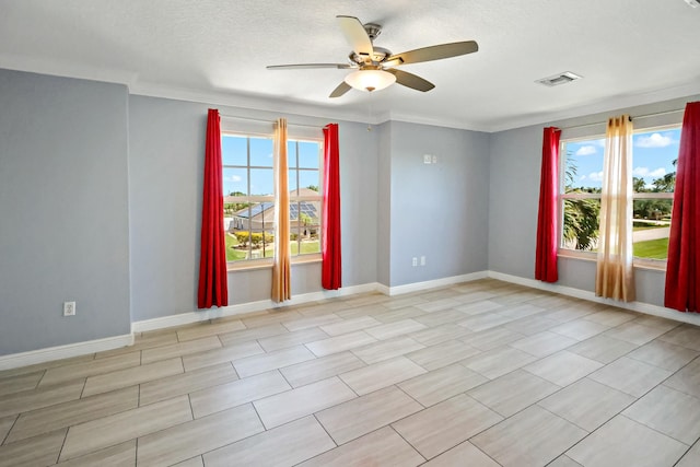 unfurnished room with a ceiling fan, healthy amount of natural light, crown molding, baseboards, and a textured ceiling