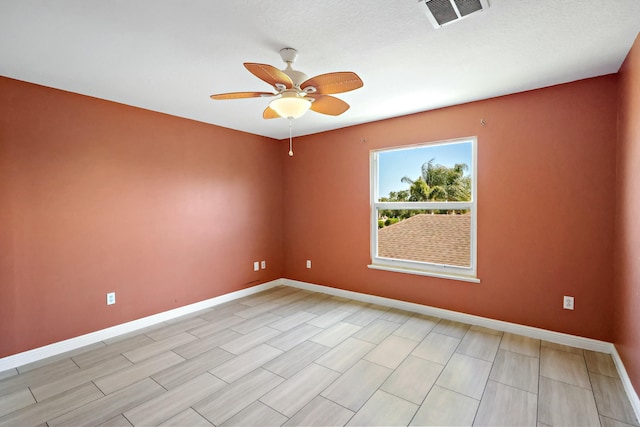spare room with ceiling fan and baseboards