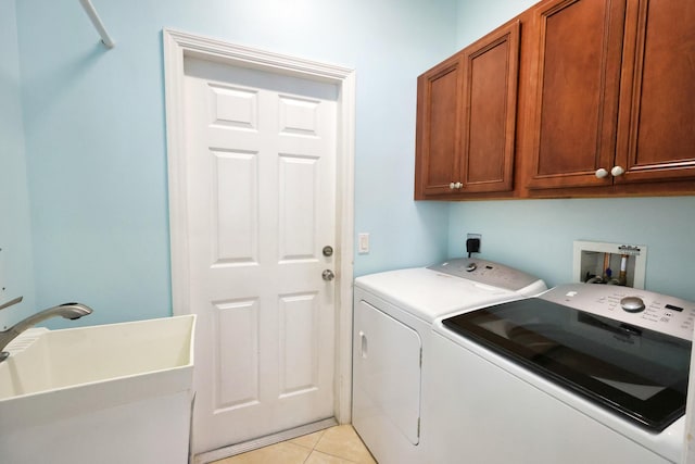 washroom featuring independent washer and dryer, cabinet space, and light tile patterned floors