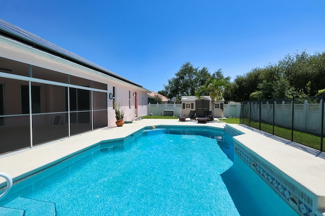 view of pool with a shed, a fenced backyard, a patio area, and an outbuilding