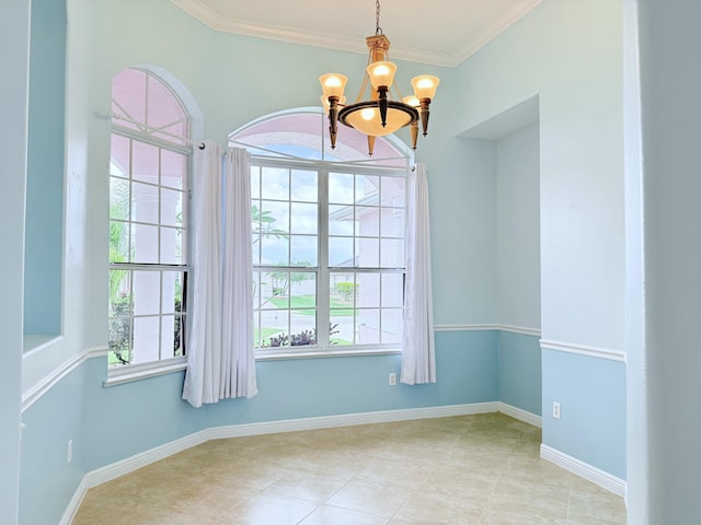 spare room featuring a chandelier, tile patterned flooring, crown molding, and baseboards