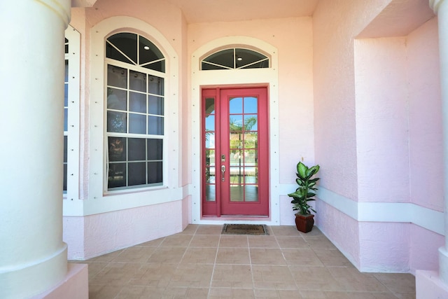 doorway to property featuring stucco siding and a porch