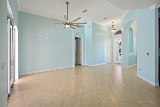 unfurnished room with arched walkways, crown molding, ceiling fan, light tile patterned floors, and baseboards