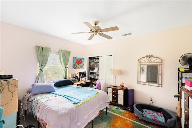 carpeted bedroom with visible vents, a closet, and ceiling fan
