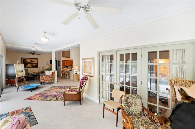 living area featuring baseboards, light tile patterned floors, ceiling fan, and french doors
